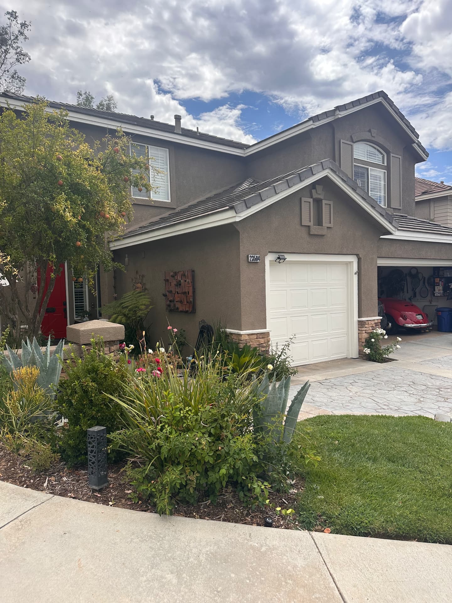 Two-story home with freshly painted stucco, crisp white trim and tidy landscaping